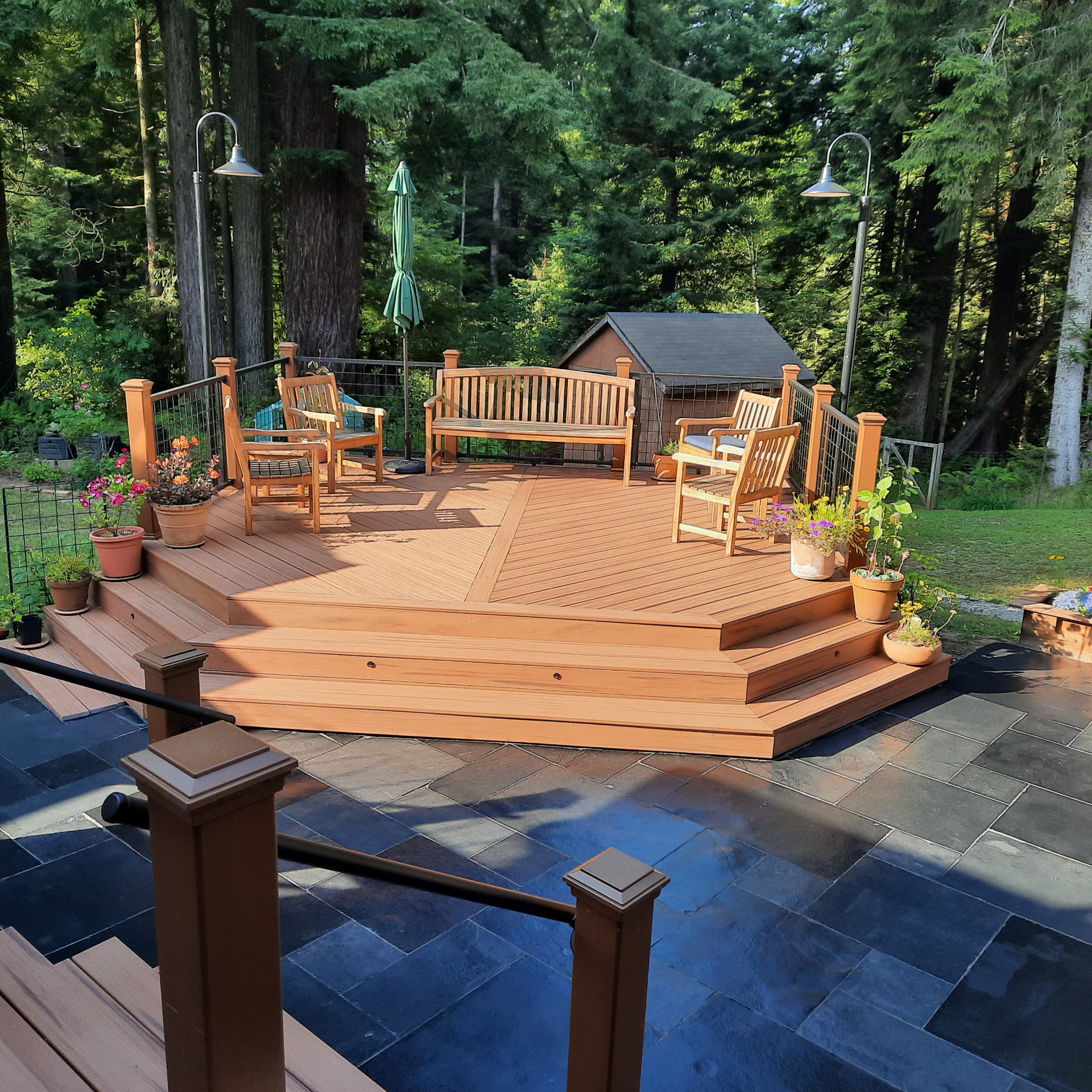 Custom composite deck and broad stair build by Living Earth Landscapes
